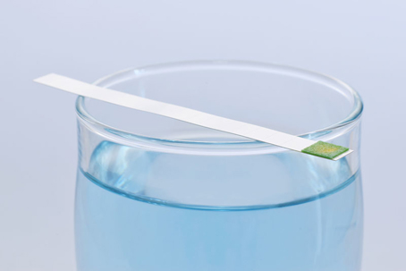 a glass of water and solution with a test kit