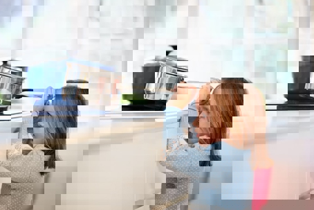 a child holding a soup pot